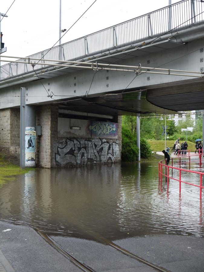 überflutete Straße unter Bahnbrücke