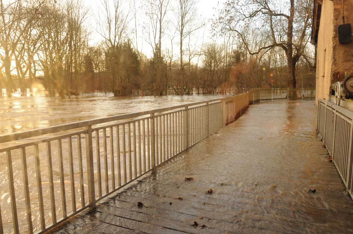 überschwemmte Brücke am Flussufer